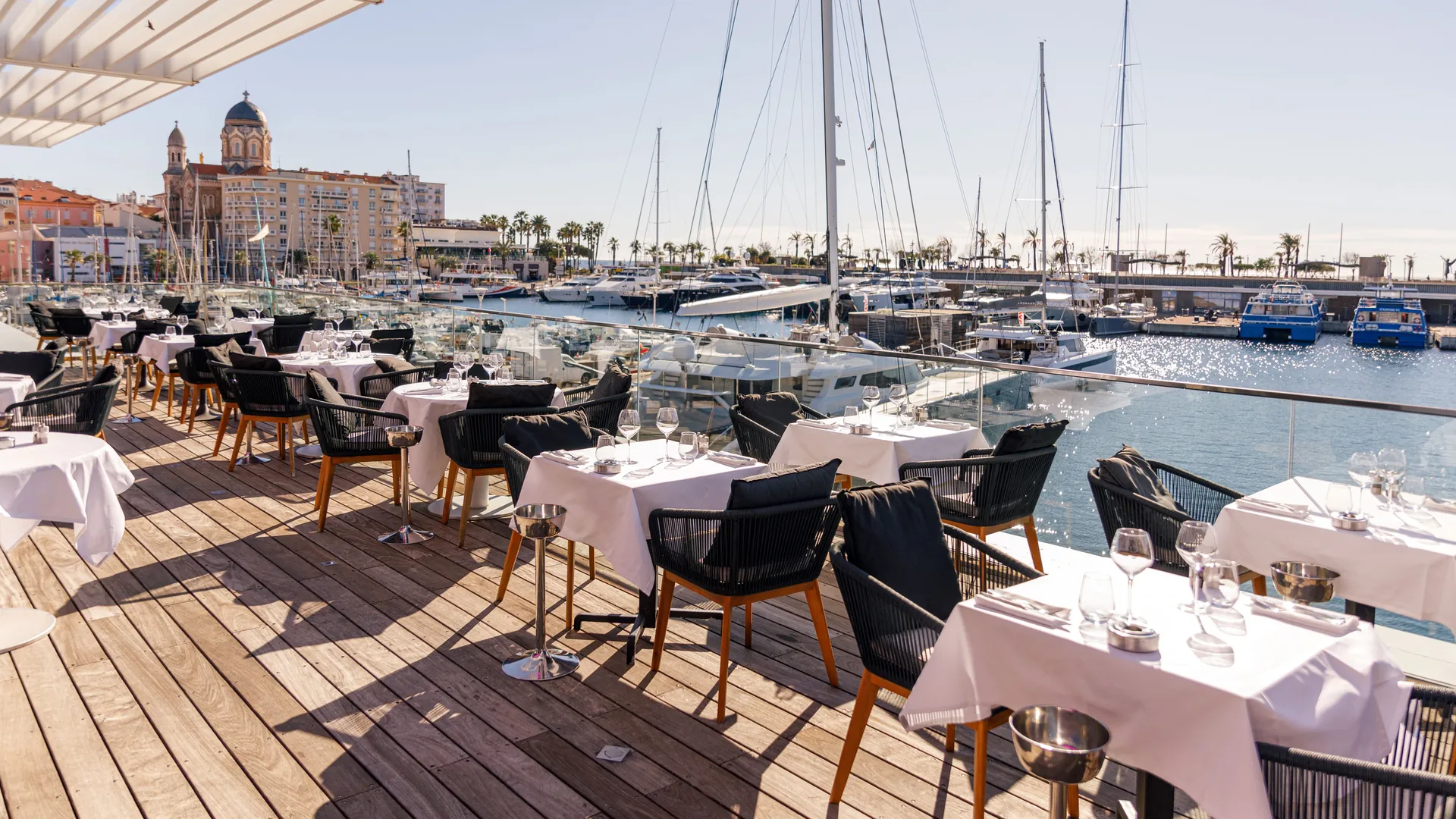 Terrasse de restaurant face au port de Saint-Raphaël, tables dressées