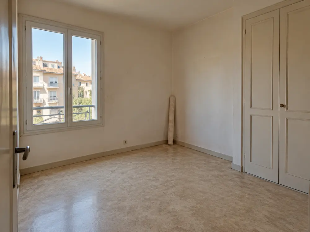 Simulation avant travaux : chambre vide aux murs défraîchis